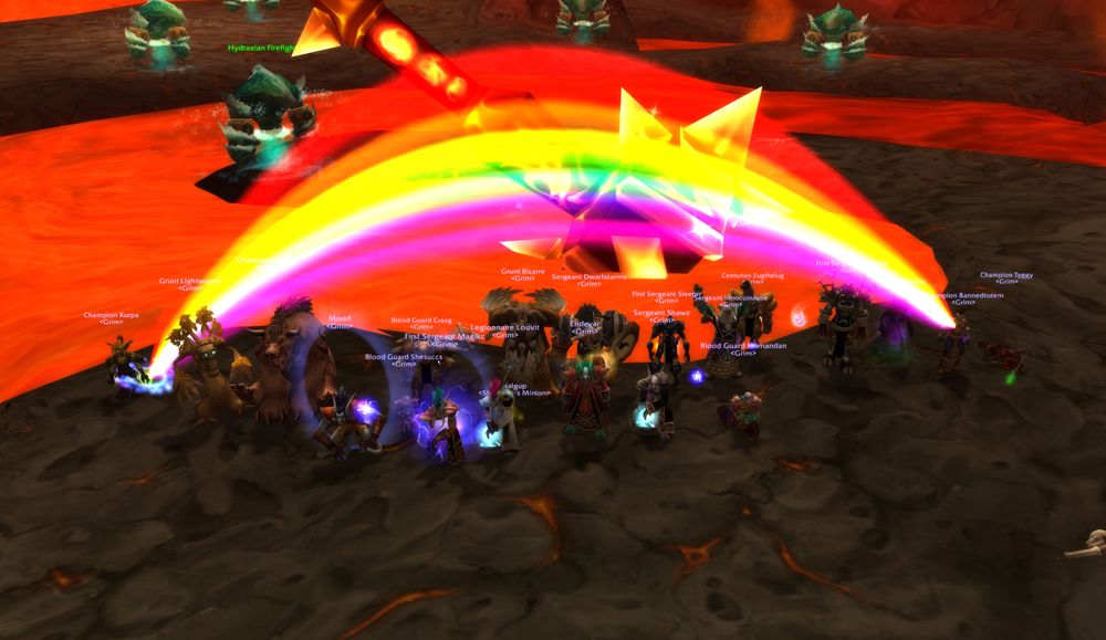 A Grim raid group standing over Ragnaros's remains in Molten Core, a bright rainbow arcing across the lava behind them.